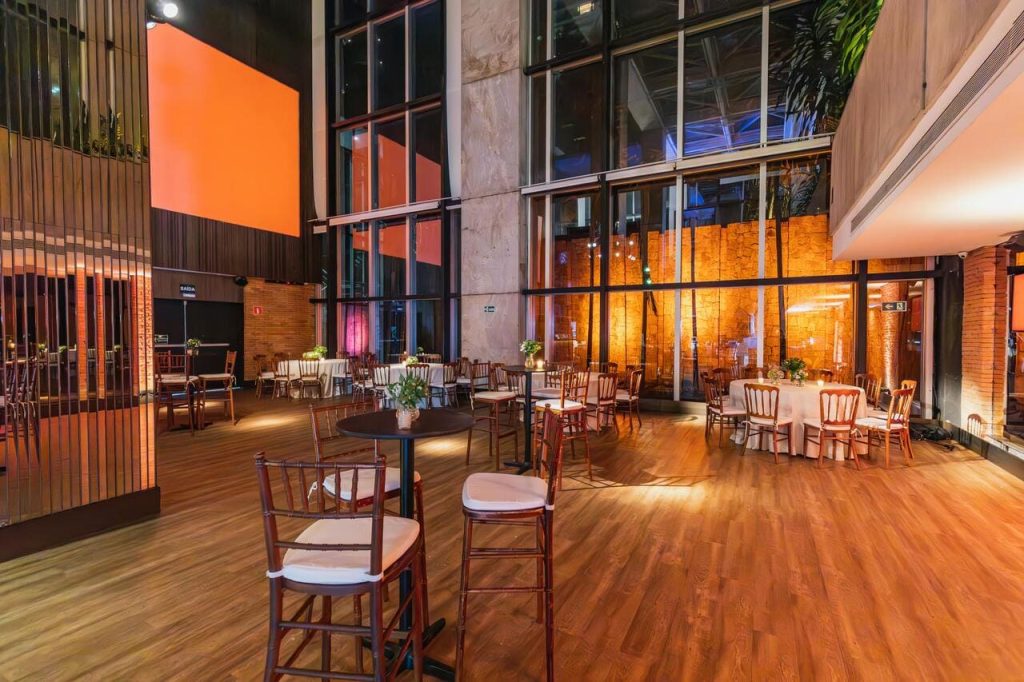 Unutrašnjost dvorane sa postavljenim stolovima i stolicama pored velikog staklenog zida